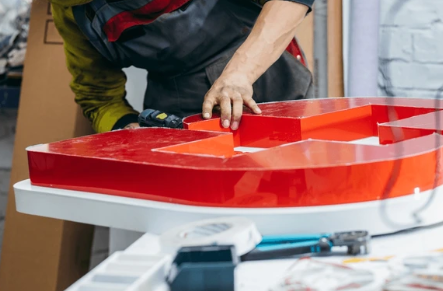 Professional commercial sign installation crew mounting channel letters on building